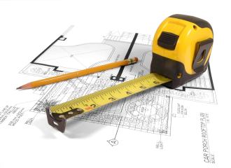 Tape measure and pencil laying on an architectural floor plan